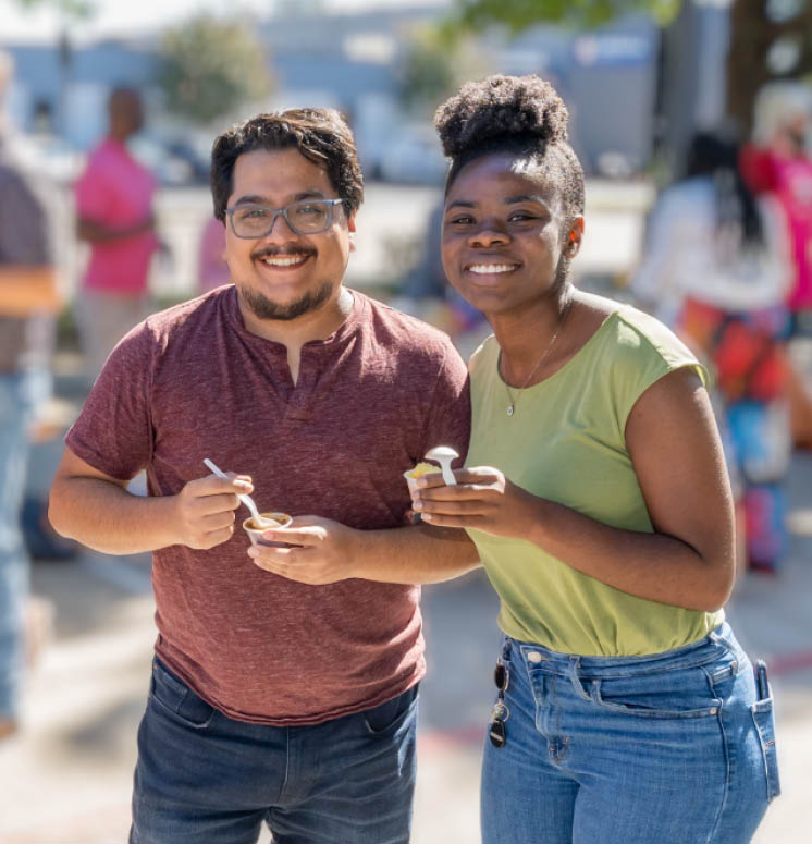 Two Halff employees enjoying a cup of chili at the annual Halff Chili Cookoff in October 2023